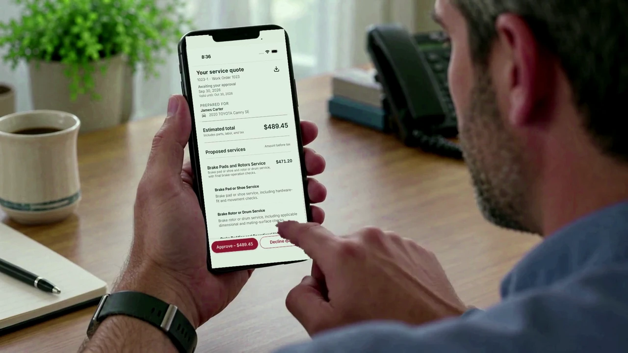 James reviews the quote summary on his iPhone with his fingertip near the quote approval button.